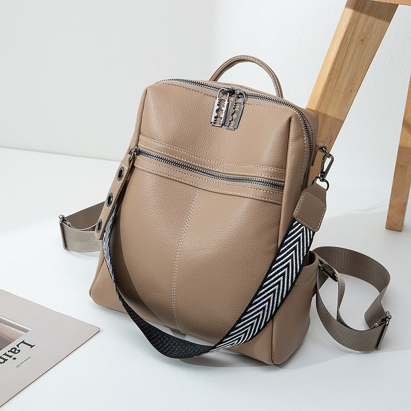 Beige backpack with a patterned strap on a white surface